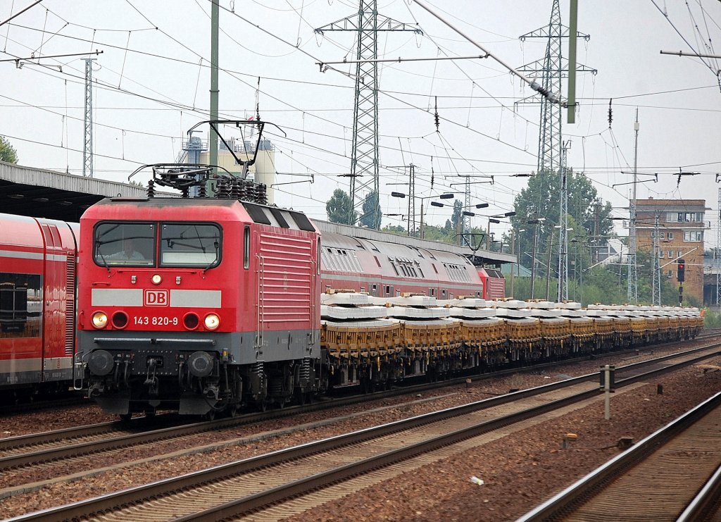 143 820-9 mit einer G�terzugleistung, hier Ganzzug Niederborwagen mit Betongleisschwellen beladen, 12.08.10  Durchfahrt im Bhf. Flughafen Berlin-Sch�nefeld. 