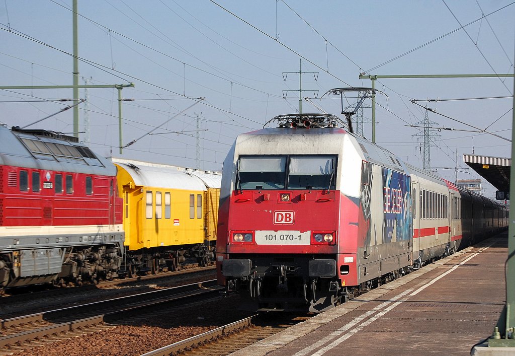 Bei herrlichem Sonnenschein kommt �berraschend die Hertha 101 070-1 mit IC und �BB EC Wagen durch den Bhf. Flughafen Berlin-Sch�nefeld gefahren, ein sch�ner Farbkontrast zu dem im Bhf stehenden Gleisbauzug, 22.02.11