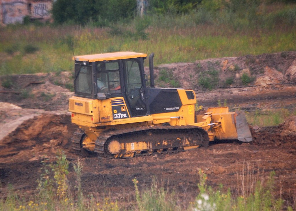 Bild durchs S-Bahnfenster, eine KOMATSU D37PX Raupe bei Erdarbeiten auf dem ehemaligen Bahnbetriebsgel�nde Berlin-Heinersdorf, 01.07.10 