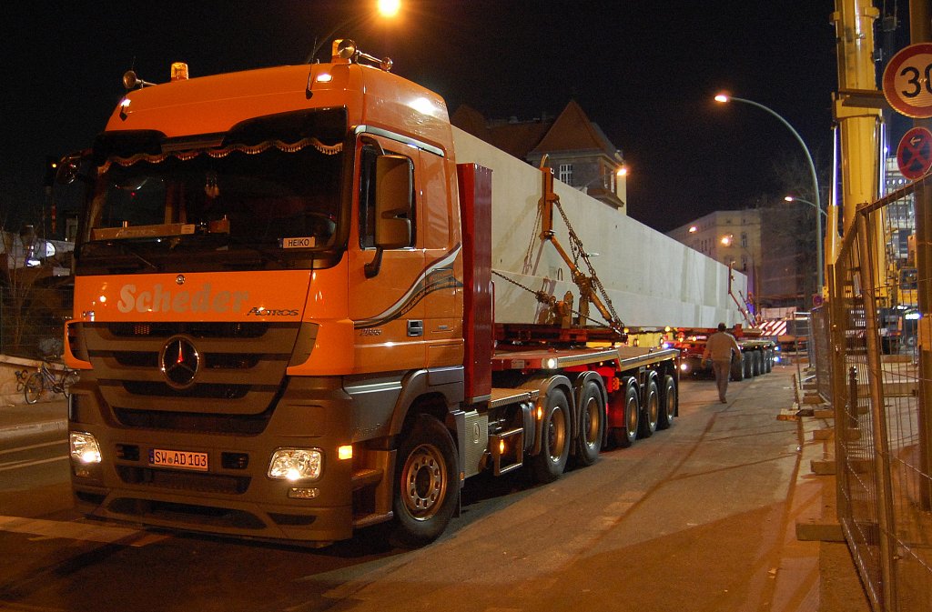 Der erste von meheren Schwerlastz�gen ist an der Baustelle gegen�ber dem S-Bhf. Berlin Pankow angekommen. Die Sped. Scheder mit der Schwerlastzugmaschine MB ACTROS 2655 mit Auflieger und Nachl�ufer mit einer zwar nicht �berm��ig schweren oder unf�rmigen Last, daf�r aber mit recht beeindruckender L�nge, ein Betonfertigteil, einige Passanten sprachen von 31 m ich w�rde eher auf knapp 40 m tippen, angekommen, 26.03.12 ca. 20:45 Zum Abladen steht ein LIEBHERR LTM 1500 von MOBI-HUB bereit.
