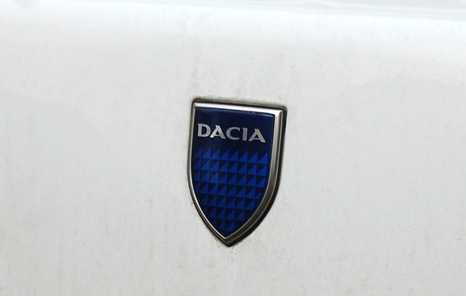 Der rumm�nische Autohersteller Dacia (SC Automobile Dacia SA) wurde 1966 gegr�ndet und kooperierte von Anfang an eng mit dem franz�sischen Hersteller Renault. 1999 erwarb der Konzern Renault-Nissan alle Firmenanteile, der Name blieb allerdings, dieses blaue Herstellerlogo ziert nun seit l�ngerem die neueren Dacia-Modelle.