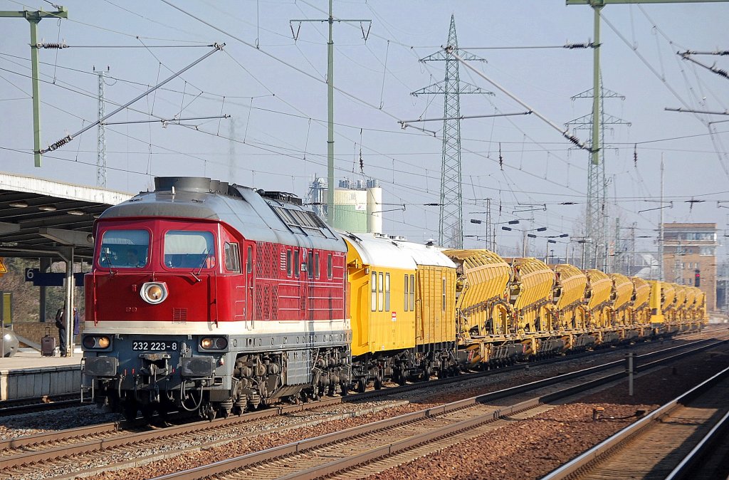 Die DB Bahnbau Gruppe mit 232 223-8 (Lugansk Bj.1975) mit Gleisbauzug mit Bahndienstwagen und einer Reihe Materialf�rder- und Siloeinheiten MFS 100 bei der Durchfahrt im Bhf. Flughafen Berlin-Sch�nefeld, 22.02.11 