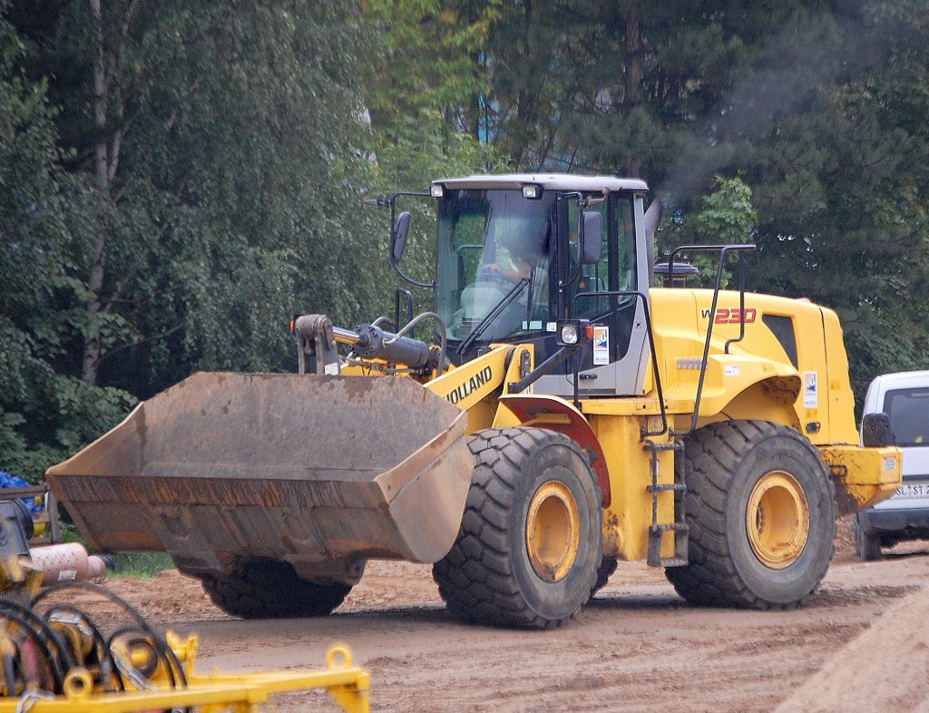 Diesmal vollst�ndig erwischt, der schon recht gro�e Radlader NEW Holland Typ W230 (HKL-Leasingbaumaschine), 09.09.10 Baustelle Flughafen Berlin-Sch�nefeld.