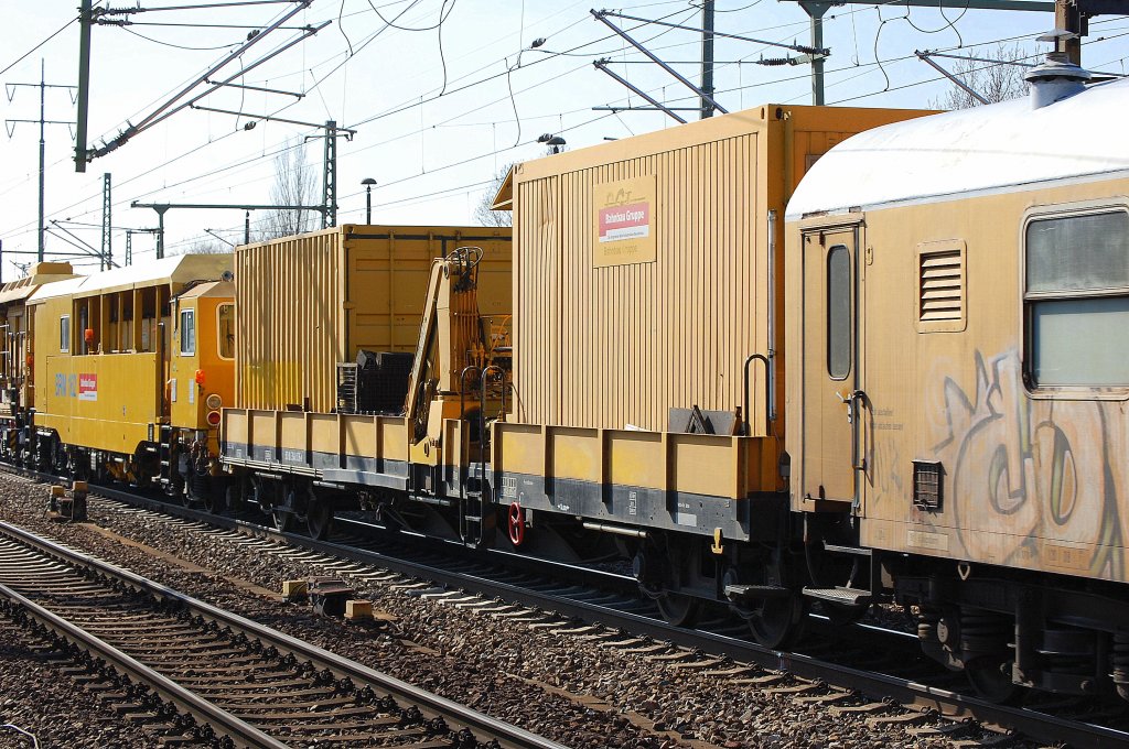 Diverse Flachwagen mit Bau- und Werzeugcontainern in einem Gleisschotterreinigungszug der DB Bahnbaugruppe am 22.03.12 Bhf. Flughafen Berlin-Sch�nefeld.