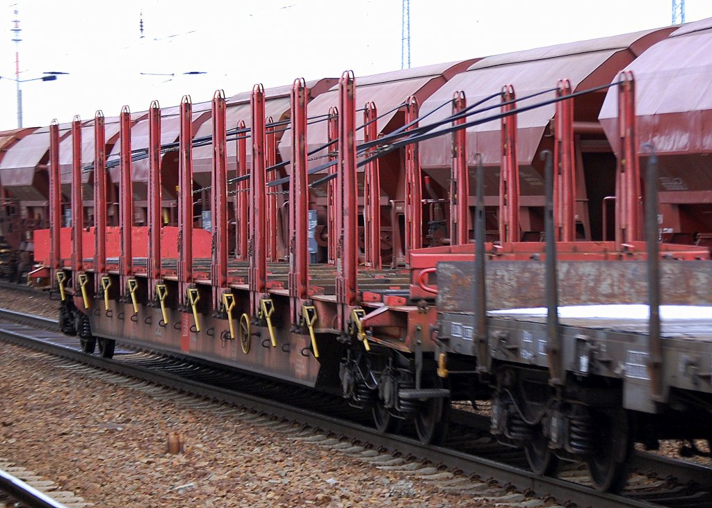 Drehgestell-Flachwagen mit Rungen und Niederbindeeinrichtung der DB vom Typ Rbns 646.1 der aktuellsten Version (in Polen gebaut) in einem gemischten G�terzug, 15.02.12 Bhf. Flughafen Berlin-Sch�nefeld.