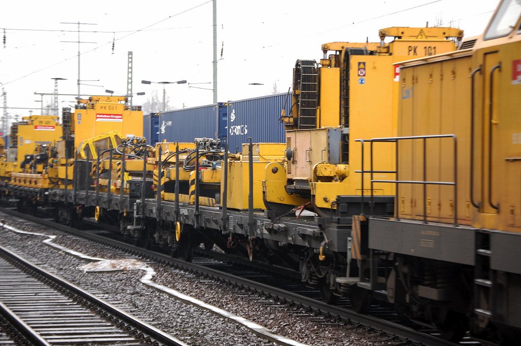 Drehgestellflachwagen mit Robel Maschine PK 101 der DB Bahnbau Gruppe (DGT) gezogen von 293 007-1  Lok 1  am 16.01.12 Bhf. Flughafen Berlin-Sch�nefeld. 