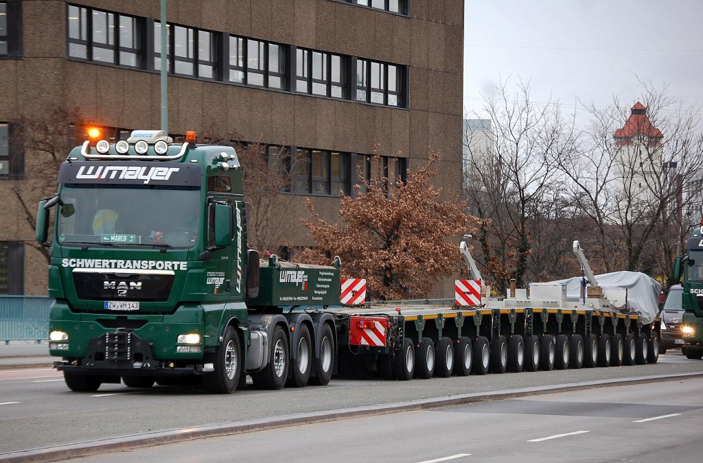 Ein intertessanter Schwertransporter vierlie� unbeladen das Berliner Westhafengl�nde in Begleitung von Polizei und Transportbegleitfahrzeug, eine MAN TGX 41.540 Schwerlastzugmaschine der Sped. w.mayer mit 17 achsigen Schwerlasth�nger, 09.01.12 Berlin-Putlitzbr�cke.