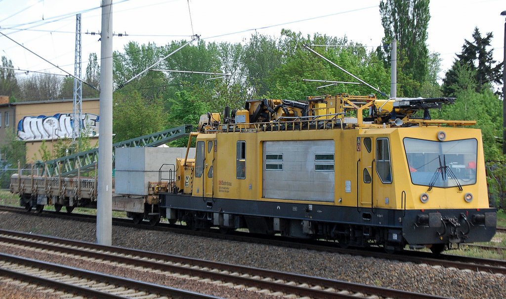 Ein Oberleitungs-Montagefahrzeug OMF 1 (97 99 10 101 17-4, ex BR 706) der DB Bahnbau GmbH (DB Bahnbau Gruppe)steht mit Drehgestellflachwagen beladen Mit Oberleitungsmast und Betonfundamenten in Berlin Blankenburg, 02.05.12