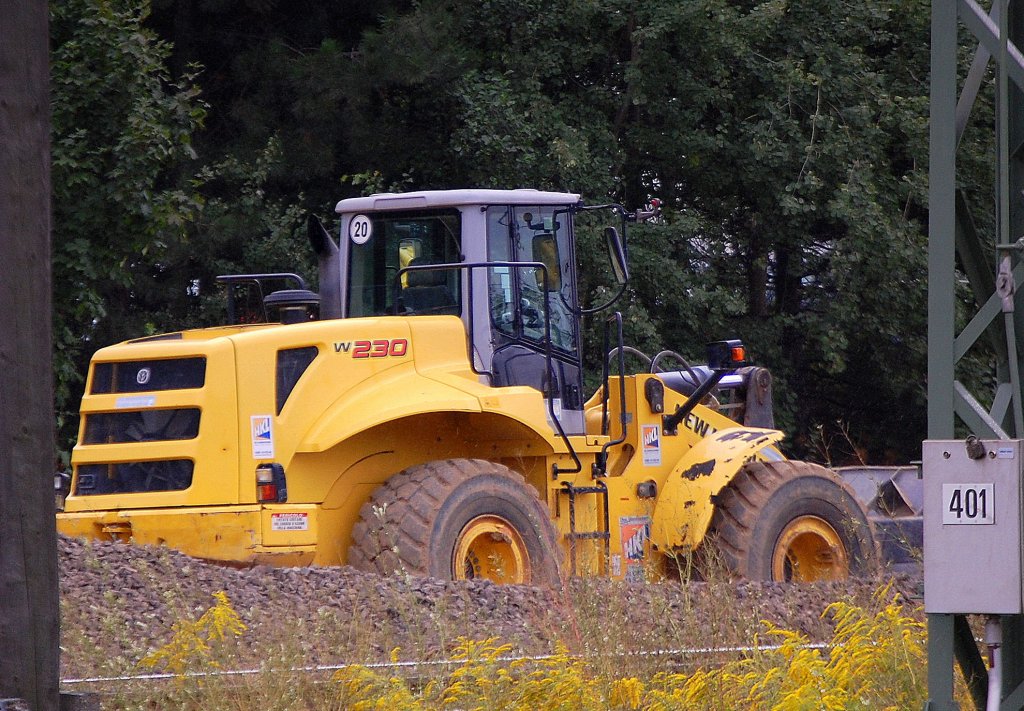 Ein recht gro�er Radlader, ein NEW HOLLAND W230 (HKL Leasingbaumaschine), 02.09.10 Baustelle am Bhf. Flughafen Berlin-Sch�nefeld.