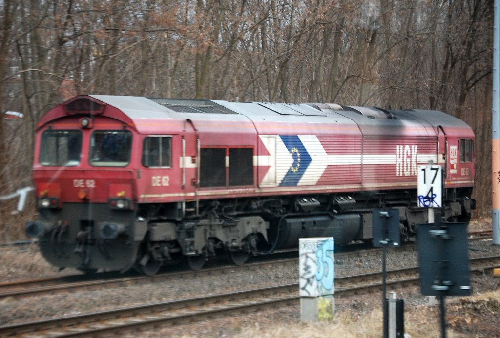 Ein reines Belegbild durchs S-Bahnfenster, da am dortigen unzug�nglichen Ort Bilder nicht m�glich sind. Immer N�he Gbf. Berlin-Neuk�lln steht jetzt regelm��ig eine der Loks der HGK Claas 66 Flotte in Bereitschaft, diesmal die immer noch in  der alten Farbgebung existierende DE 62 (92 80 1266 062-9 D-HGK), 14.03.12   