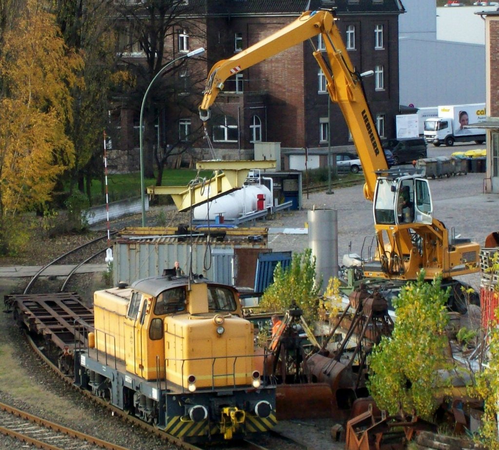 Ein Umsschlagbagger mit der typischen h�henverstellbaren F�hrerkanzel im Berliner Westhafen, es ist der LIEBHERR 934 der BEHALA am 10.11.08
Im Bildvordergrund steht die BEHALA Lok 10 (KM, Bj.1966, Typ M800BB) 