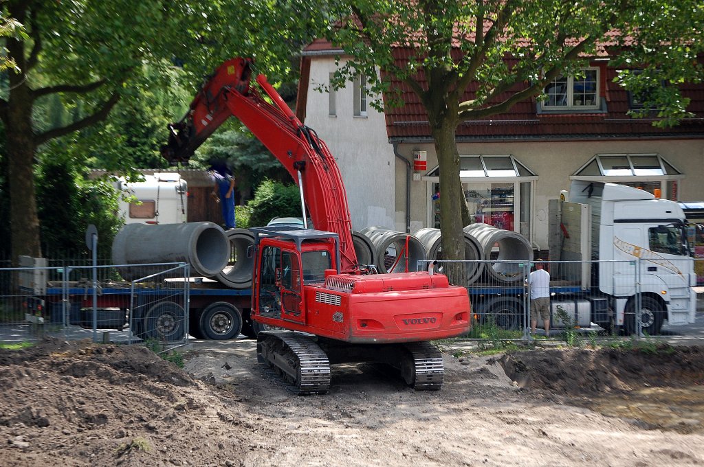 Ein VOLVO EC290 Raupenbagger hebt gerade gewaltige Betonr�hren von einer LKW-Tiefladefl�che f�r den Discounterneubau am 15.07.09 neben dem S-Bhf. Berlin-Karow.