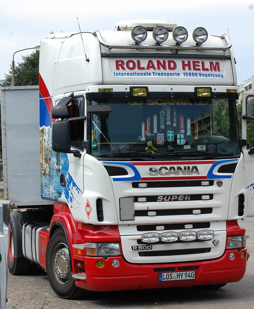 Eine sehr sch�ne Zugmaschine mit Seitenbemalung, ein SCANIA R500 der Fa. ROLAND HELM mit Flachauflieger wartet auf Enzelsegmente eines Hochkrans, 06.08.13 Berlin-Pankow.
