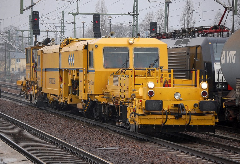 GBW Gleistopfmaschine P&T 08-275 UNIMAT 3S + Schotterplaniermaschine SSP 100 der Deutschen Plasser bei der Durchfahrt im Bhf. Flughafen Berlin-Sch�nefeld, 03.02.11