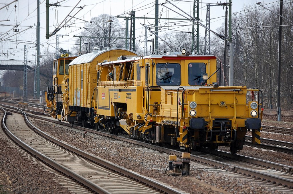 Gleisarbeitszug der DB Bahnbau Gruppe mit Stopfmaschine P&T 09-32 CSM (GSM 151 ) * Dienstwagen (D-DB 0801411017-0 Gos HG 100) + Schnellschotterplaniermaschine Dt.Plasser Typ SSP 110 SW (SSP 502/97 16 40 562 17-1) am 20.03.12 Bhf. Flughafen Berlin-Sch�nefeld Richtung Gbf. Berlin-Neuk�lln.