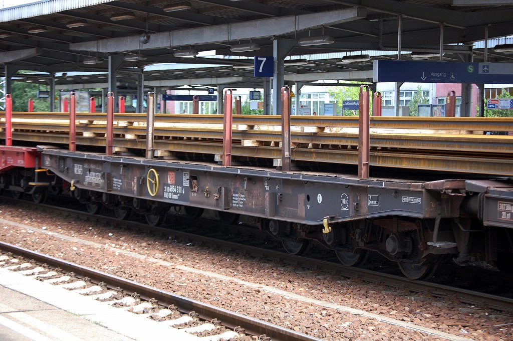 Hier ein weiterer Drehgestellflachwagen mit Rungen + sechs Rass�tzen der DB mit der Nr. 31 RIV 80 D-DB 4864 311-4 Samms 709, Schienenlangtransport am 16.08.10 Bhf. Flughafen Berlin-Sch�nefeld.