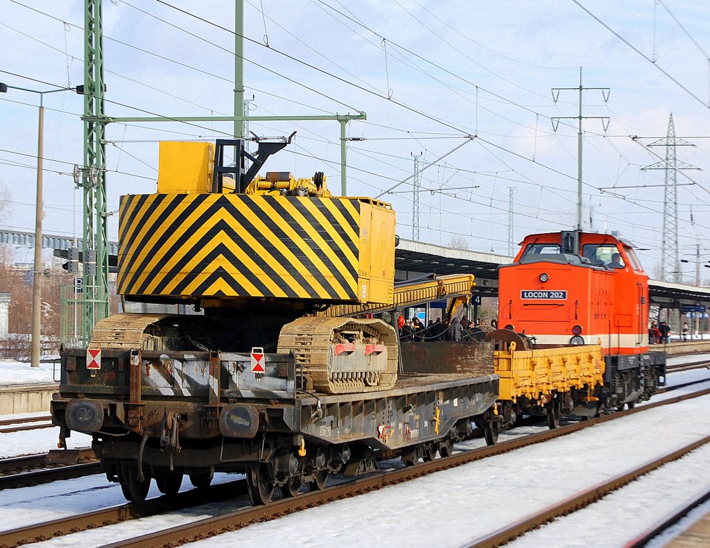 Hier noch mal von hinten, diese ungew�hnliche Baumaschine auf einem Schwertransportwagen gezogen von LOCON 202 am 20.02.10 durch den Bhf. Flughafen Berlin-Sch�nefeld. 