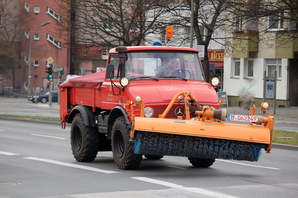 Interessanter alter MB Unimog mit Kehrrolle und Streutrichter, inzwischen privat genutzt von einer Fa.? geh�rte dieser UNIMOG wohl einst zum Fuhrpark der Berliner Feuwerwehr wie man auf den Seitent�ren noch deutlich lesen kann, 10.04.12 Berlin-Beusselbr�cke.
