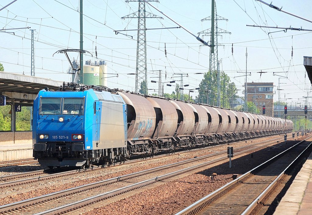 Inzwischen f�r EKO Trans t�tig, die Leasinglok 185 523-8 (94 80 0 185 523-8, Bombardier Bj.2003)) mit einem Ganzzug Silostaubwagen (Steinkohlestaub) bei der Durchfahrt im Bhf. Flughafen Berlin-Sch�nefeld, 09.05.11