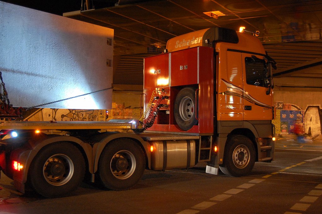 Keine Monsterschwerlastzugmaschine, der MB ACTROS 2655 der Sped. Scheder, trotzdem mit der langen Fracht eine beeindruckende Szenerie im Dunkeln beim Einf�deln unter der Bahnbr�cke zur Baustelle hin am 26.03.12 Berlin-Pankow.