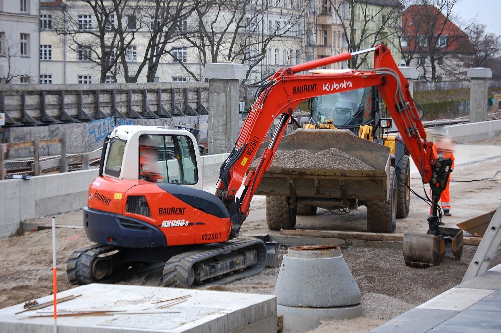 Leasingbaumaschine, ein Minibagger KUBOTA KX080-3 der Fa. BAURENT bef�llt die Schaufel des JCB Radladers mit Kies, 07.02.11 Baustelle S-Bf. Berlin-Baumschulenweg.