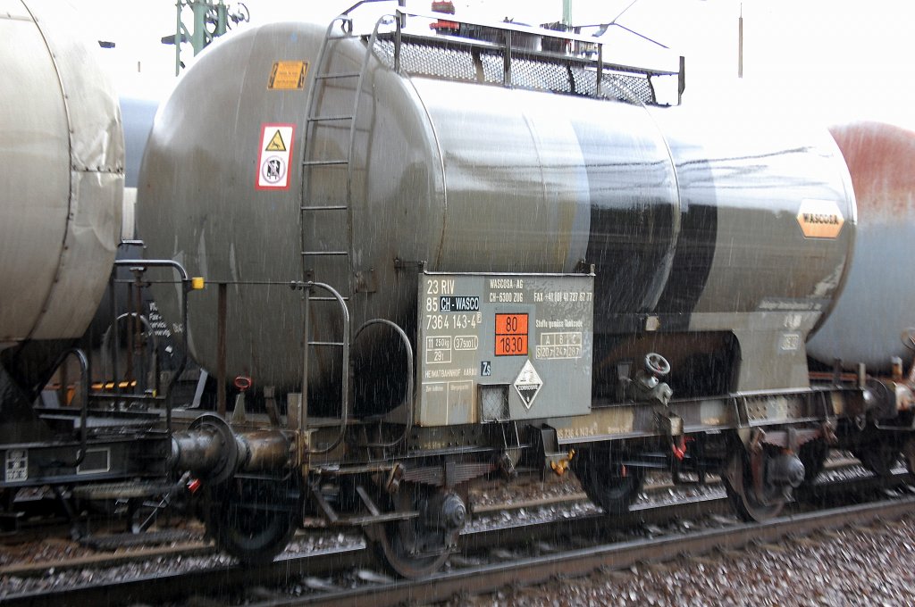Leider regnete es gerade in Str�men, aber Kesselwagen mit zwei Rads�tzen sieht man nicht gerade h�ufig im Berliner Raum, hier ein Wagen vom schweizer Wageneinsteller Wascosa AG mit der Nr. 23 RIV 85 CH-WASC 7364 143-5(P) Zs lt. Gefahrstofftafel (80/1830) f�r den Transport von Schwefels�ure, 02.09.10 Bhf. Flughafen Berlin-Sch�nefeld. 