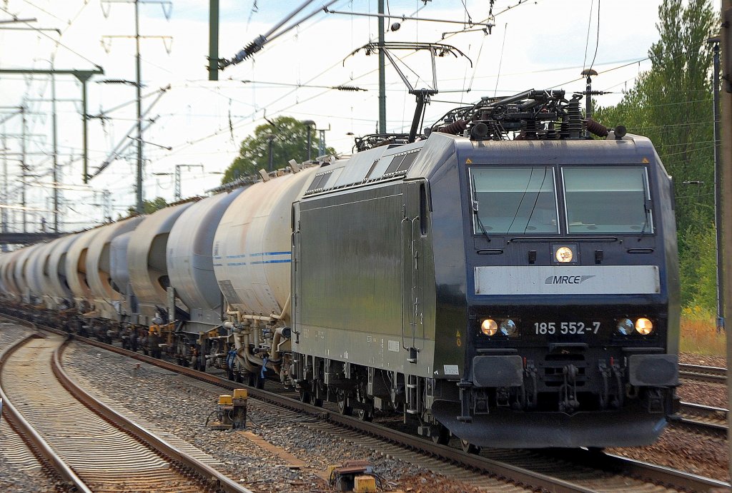 MRCE Leasinglok 185 552-7 (Bombardier, Bj.2005), 07.08.09 mit einem Ganzzug Staubsilowagen bei der Durchfahrt im Bhf. Flughafen Berlin-Sch�nefeld. 