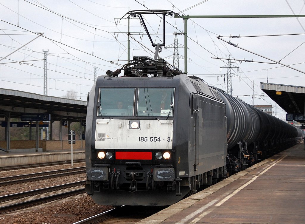 MRCE Leasinglok 185 554-3 von CFL Cargo Deutschland angemietet mit Kesselwagenzug bei der Durchfahrt im Bhf. Flughafen Berlin-Sch�nefeld, 14.03.12