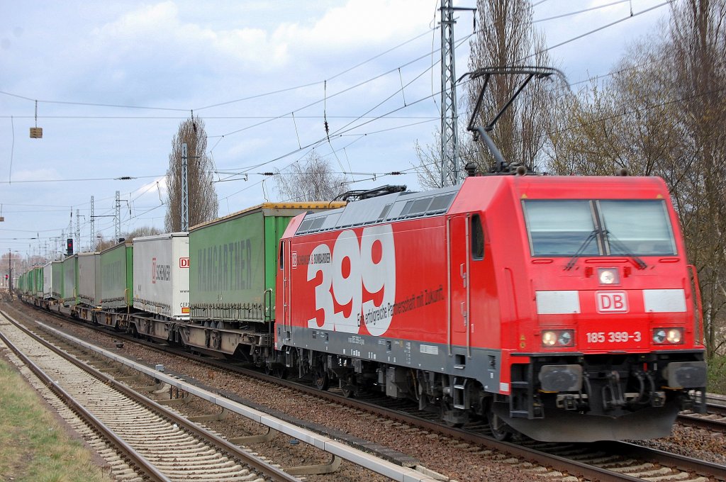 Nicht 100 %&acute;tig scharf (schade), trotzdem eine �berraschung Mittags auf die 185 399-3 mit dem bekannten Seitenlogo mit einem Ganzzug Taschenwagen mit HANGARTNER + DB SCHENKER LKW Aufliegern an meinem Stammplatz Berlin-Karow zu treffen, unterwegs Richtung Karower Kreuz Berlin, 04.04.11