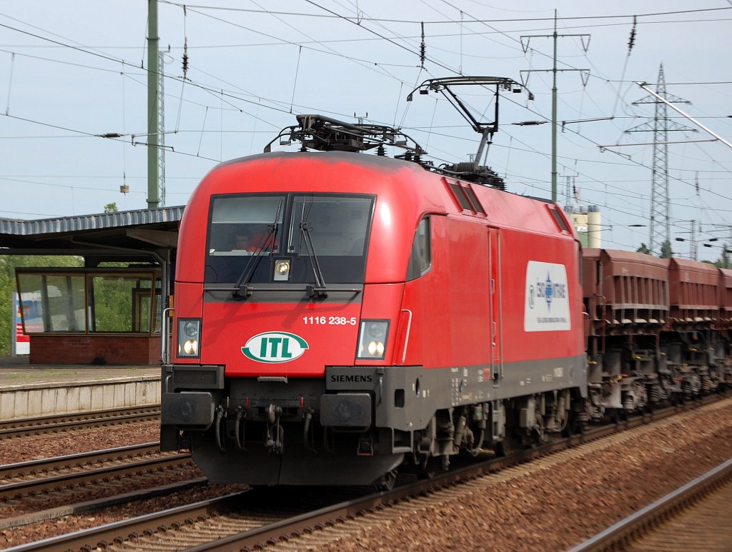 �BB Taurus als ITL-Leasinglok 1116 238-5 (Siemens, Bj.2004)am 09.05.09 mit Schotterwagen bei der Durchfahrt im Bhf. Flughafen Berlin-Sch�nefeld.