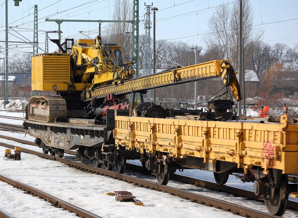 Raupenantrieb und wahrscheinlich Drehbohrsystem, interessante Baumaschine auf einem Drehgestellflachwagen f�r Schwerransporte + Schutzwagen gezogen von LOCON 202 am 20.02.10 durch den Bhf. Flughafen Berlin-Sch�nefeld. 