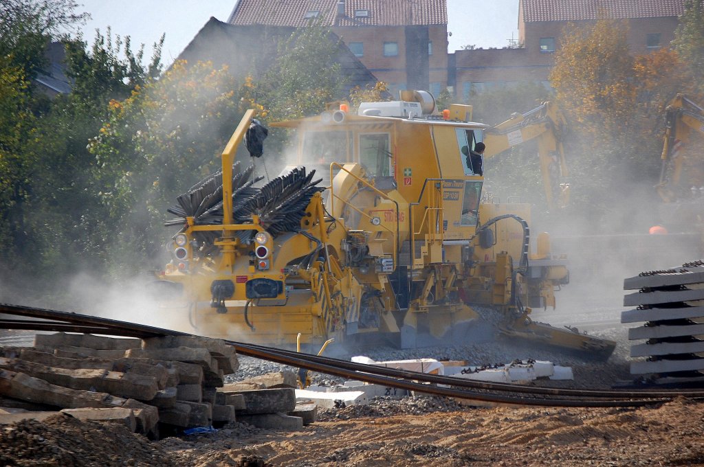 Schnellschotterplaniermaschine P&T SSP 110 SW (99 80 9425 003-7 D-STRA) der Fa. STRABAG bei deutlicher staubiger Planierarbeit bei herrlichem Sonnenschein am Bhf. Berlin-Sch�nefeld Flughafen, 09.10.10 