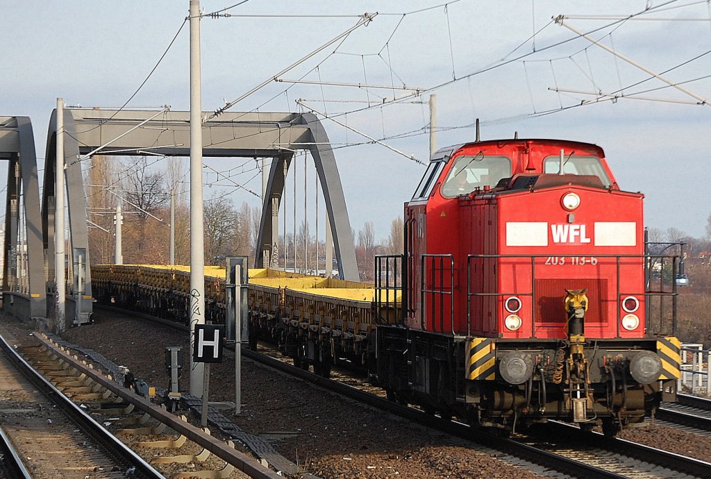 WFL Lok 21 203 113-6 (92 80 1203 113-6 D-WFL, LEW Bj.1971) mit einem Zug gelber Drehgestellflachwagen Richtung Berliner Innenstadt, 28.12.11 Berlin-Pankow.