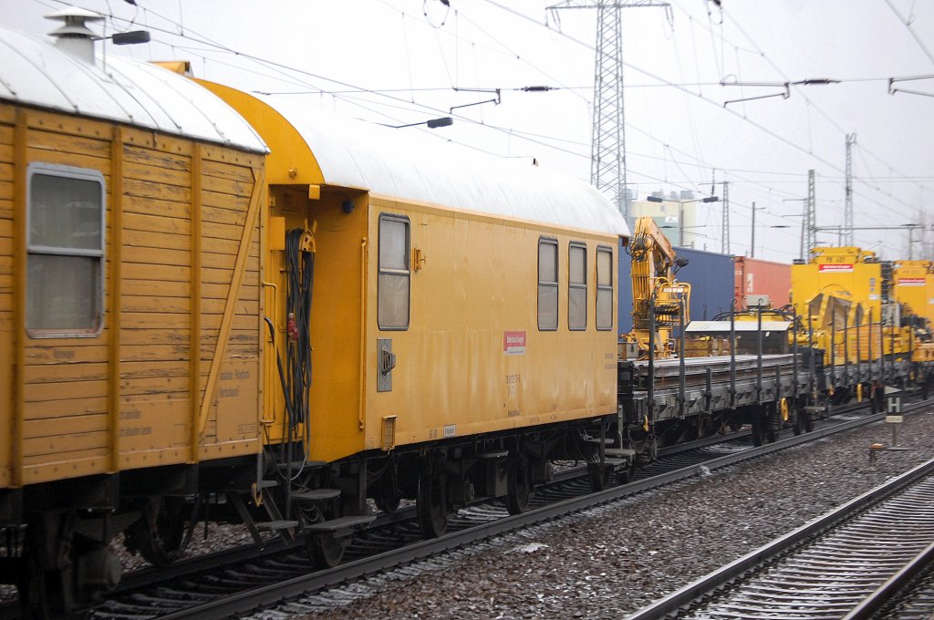 Wohnschlafwagen (ex DB) mit drei Achsen Nr nicht entzifferbar D-DGT der DB Bahnbau Gruppe gezogen von 293 007-1  Lok 1  am 16.01.12 Bhf. Flughafen Berlin-Sch�nefeld. 