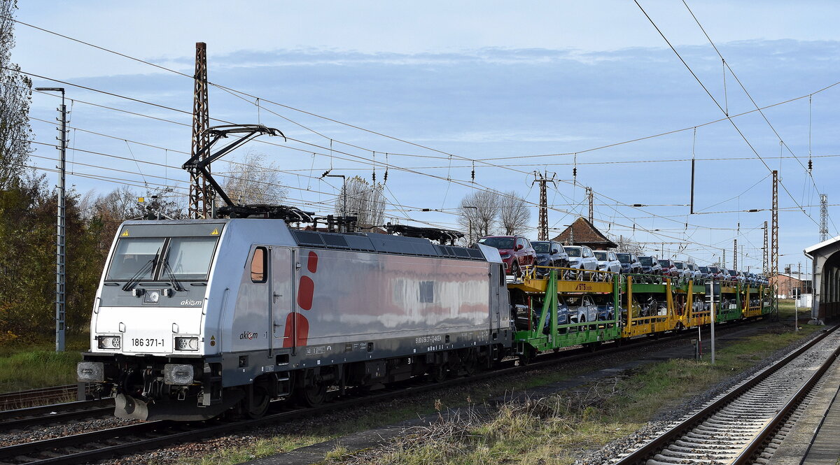 ČD Cargo a.s., Praha [CZ] mit der geleasten Akiem Lok  186 371-1  [NVR-Nummer: 91 80 6186 371-1 D-AKIEM] und einem PKW-Transportzug (fabrikneue VW PKW-Modelle) weiter Richtung Polen am 13.11.25 Höhe Bahnhof Frankfurt/Oder.