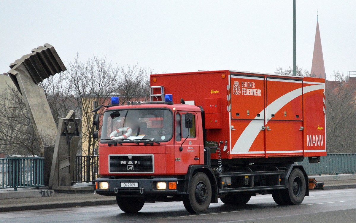 Älterer Wechsellader (WLF), ein MAN 18.232 der Berliner Feuerwehr mit dem Abrollcontainer AB-MANV  Massenanfall von Verletzten  u.a. mit Rettungszelten und Tragen uvm. beladen am 13.02.15 Berlin-Putlitzbrücke. 