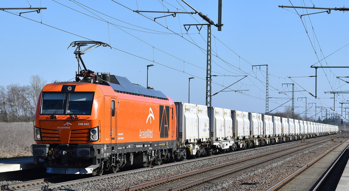 ArcelorMittal Eisenhüttenstadt Transport GmbH, Eisenhüttenstadt [D] mit ihrer Vectron Dual Lok  248 043  [NVR-Nummer: 90 80 2248 043-2 D-EKO] und einem innofreigt-Systemzug für Kalktransporte am 20.03.25 Höhe Bahnhof Rodleben.