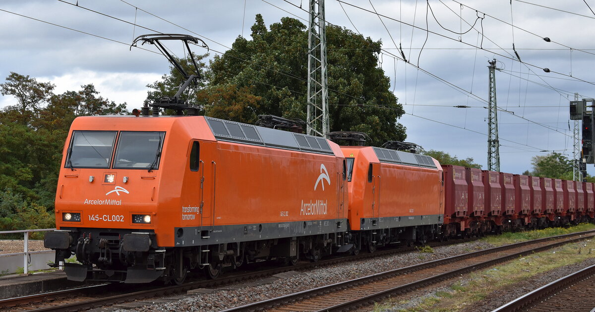 ArcelorMittal Eisenhüttenstadt Transport GmbH, Eisenhüttenstadt [D] mit ihren  145-CL 002  [NVR-Nummer: 91 80 6145 082-4 D-EKO] +  145-CL 203 /145 099-8  [NVR-Nummer: 91 80 6145 099-8 D-EKO] am Haken + dem Erzzug (leer) aus Ziltendorf EKO Richtung Hamburg am 18.09.25 Höhe Bahnhof Magdeburg-Neustadt.
