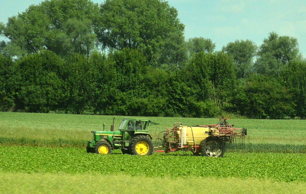 Aus dem ICE Fenster irgendwo in Niedersachsen, ein JOHN DEERE Typ? Traktor mit Hänger, 03.06.14 