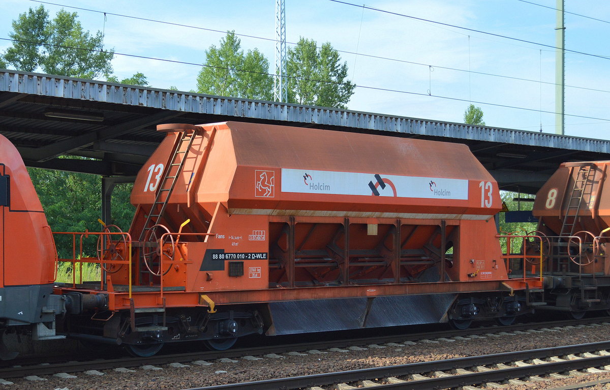 Bisher noch nie gesehen diesen Wagentyp, diese sicherlich nicht mehr ganz taufrischen Drehgestell-Schüttgutwagen mit dosierbarer Schwerkraftentladung vom Einsteller WLE, im Bild der Wagen mit der Nr. 88 80 6770 010-2 D-WLE Fans mit Firmenlogo Holcim  am 28.07.16 in einem Ganzzug baugleicher Wagen bei der Durchfahrt Bf. Flughafen Berlin-Schönefeld.