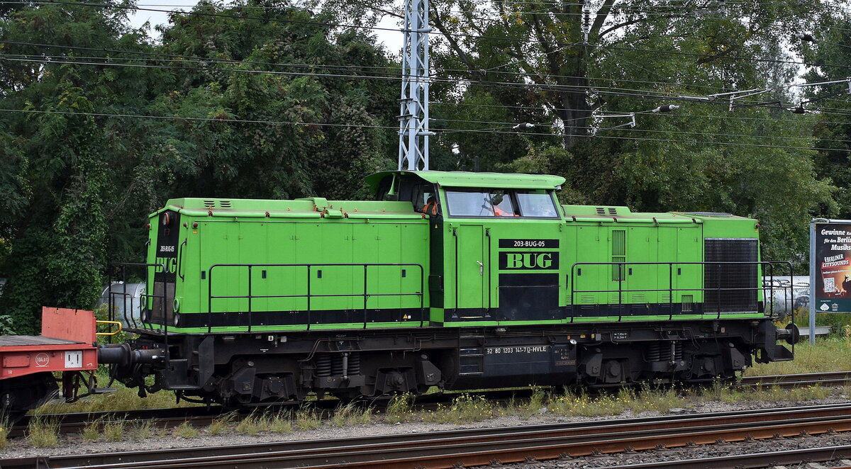 BUG Vermietungsgesellschaft mbH, Hoppegarten mit der gemieteten V 100  203-BUG-05  [NVR-Nummer: 92 80 1203 141-7 D-HVLE] und einigen Drehgestell-Flachwagen am 01.10.25 Höhe S-Bahnhof Berlin Springpfuhl.