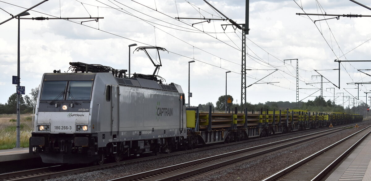 Captrain Deutschland GmbH mit der geleasten Akiem Lok  186 266-3  [NVR-Nummer: 91 80 6186 266-3 D-AKIEM] und einem Schienen-Transportzug am 23.06.25 Höhe Bahnhof Rodleben.