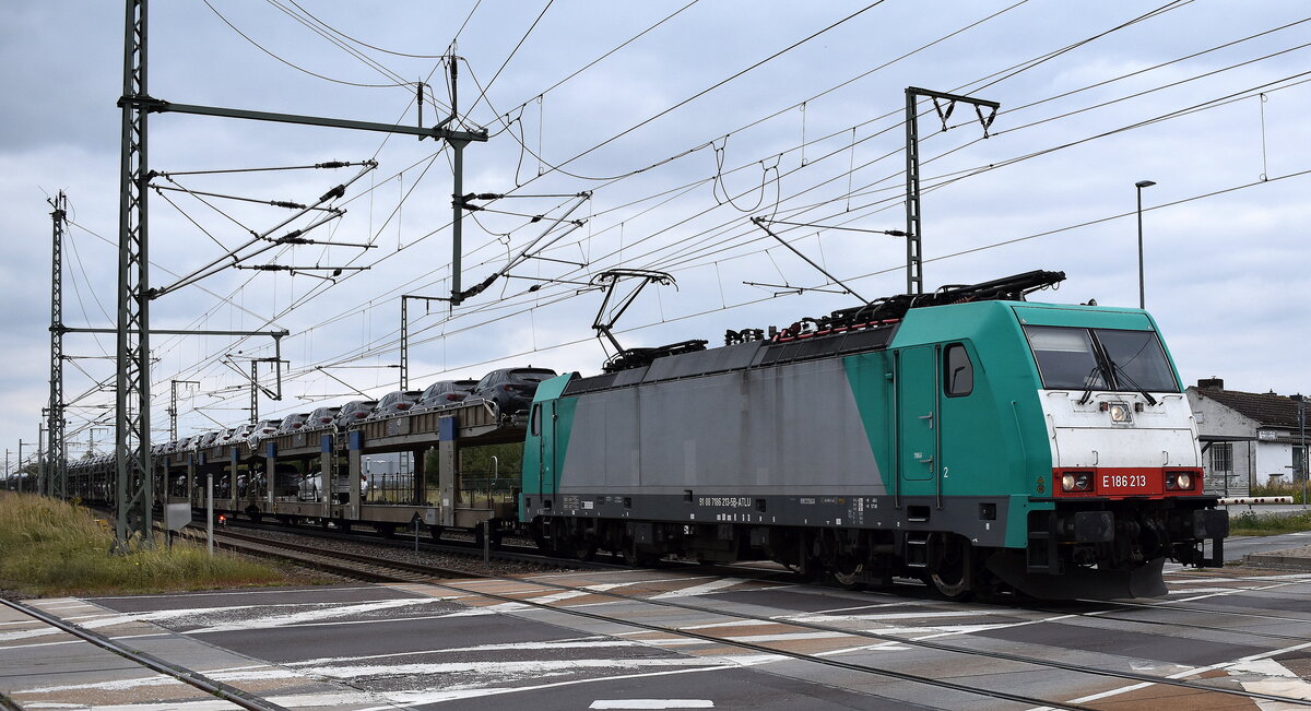 Crossrail Benelux N.V., Antwerpen-Borgerhout [B] mit der geleasten belgischen ATLU Lok   E 186 213  [NVR-Nummer: 91 88 7186 213-5 B-ATLU] und einem PKW-Transportzug am 01.10.25 Höhe Bahnübergang Rodleben.