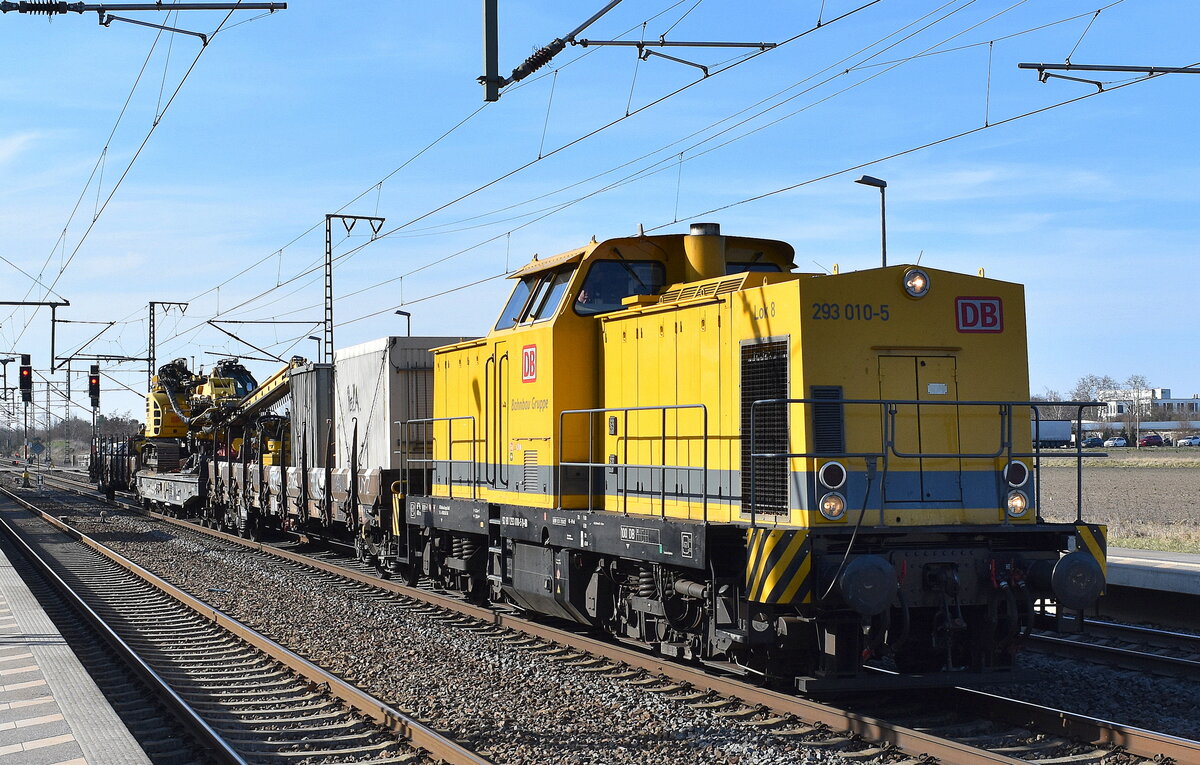 DB Bahnbau Gruppe GmbH, Berlin mit ihrer  293 010-5  [NVR-Nummer: 92 80 1293 010-5 D-DB] und Flachwagen mit Werkzeugcontainern + der firmeneigenen Kettenbohrramme Delmag G42B am 20.03.25 Höhe Bahnhof Rodleben.