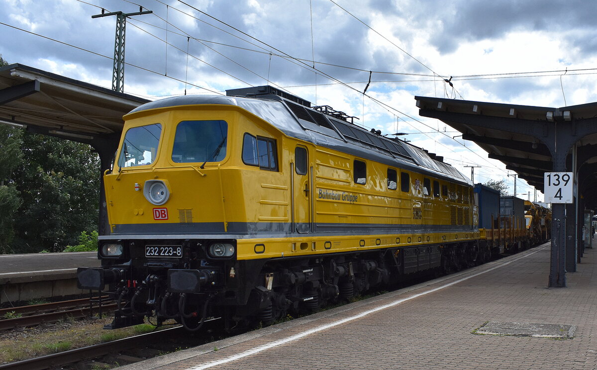 DB Bahnbau Gruppe GmbH, Berlin mit ihrer Ludmilla  232 223-8  (NVR:  92 801232 223-8 D-DB ) u. der MGW Hochleistungs-Bettungsreinigungsmaschine RM 95-700 am Haken am 01.08.25 Durchfahrt Bahnhof Magdeburg-Neustadt.