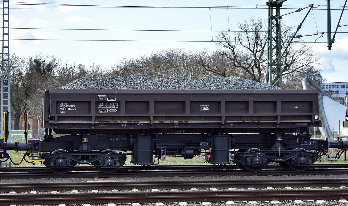 DB Bahnbau Gruppe GmbH mit einem Drehgestell-Schüttgutkippwagen zum Schottern von Gleisen mit der Nr. 33 RIV 80 D-DBBBG 9300 043-2 Uas in einem Schotterzug am 01.04.25 Höhe Bahnhof Magdeburg Neustadt.