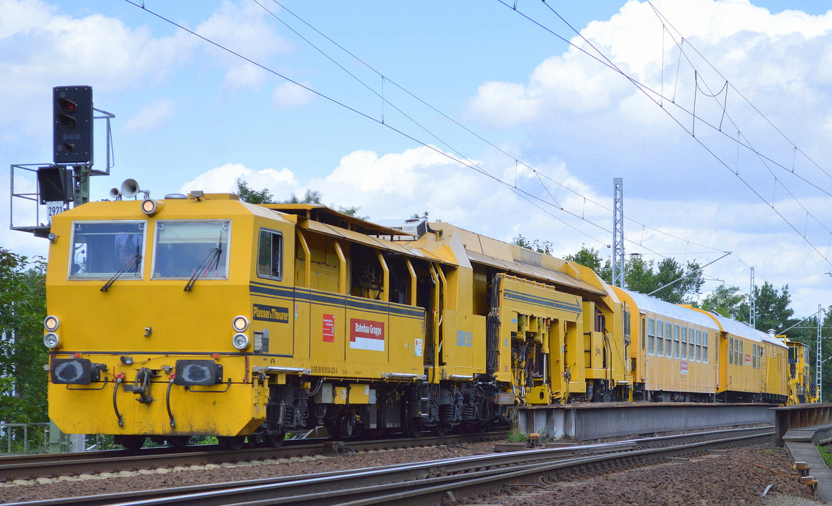 DB Bahnbau Gruppe mit der Gleisstopfmaschine P&T UNIMAT 09-16/4S (D-DB 99 80 9124 025-4) USM 351  Lotte  mit zwei Bahndienstwagen und Gleisschotterplaniermascjine am Haken am 28.07.17 Berlin-Wuhlheide.