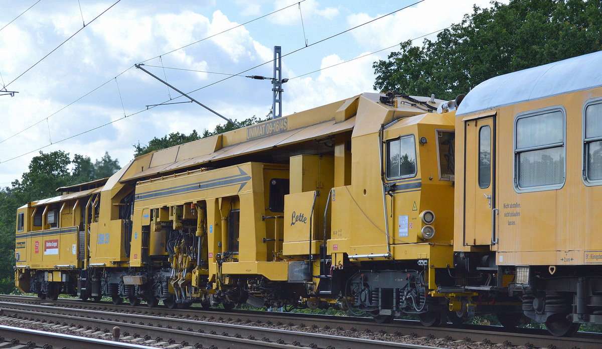 DB Bahnbau Gruppe mit der Gleisstopfmaschine P&T UNIMAT 09-16/4S (D-DB 99 80 9124 025-4) USM 351  Lotte  mit zwei Bahndienstwagen und Gleisschotterplaniermascjine am Haken am 28.07.17 Berlin-Wuhlheide.