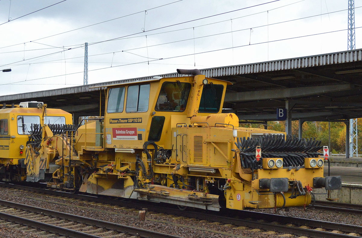DB Bahnbau Gruppe mit der Gleisstopfmaschine P&T 08-275 UNIMAT 3S (USM 165) und der Schotterplaniermaschine P&T SSP 110 SW (SSP 371?) am 11.11.17 BF. Flughafen Berlin-SChönefeld.