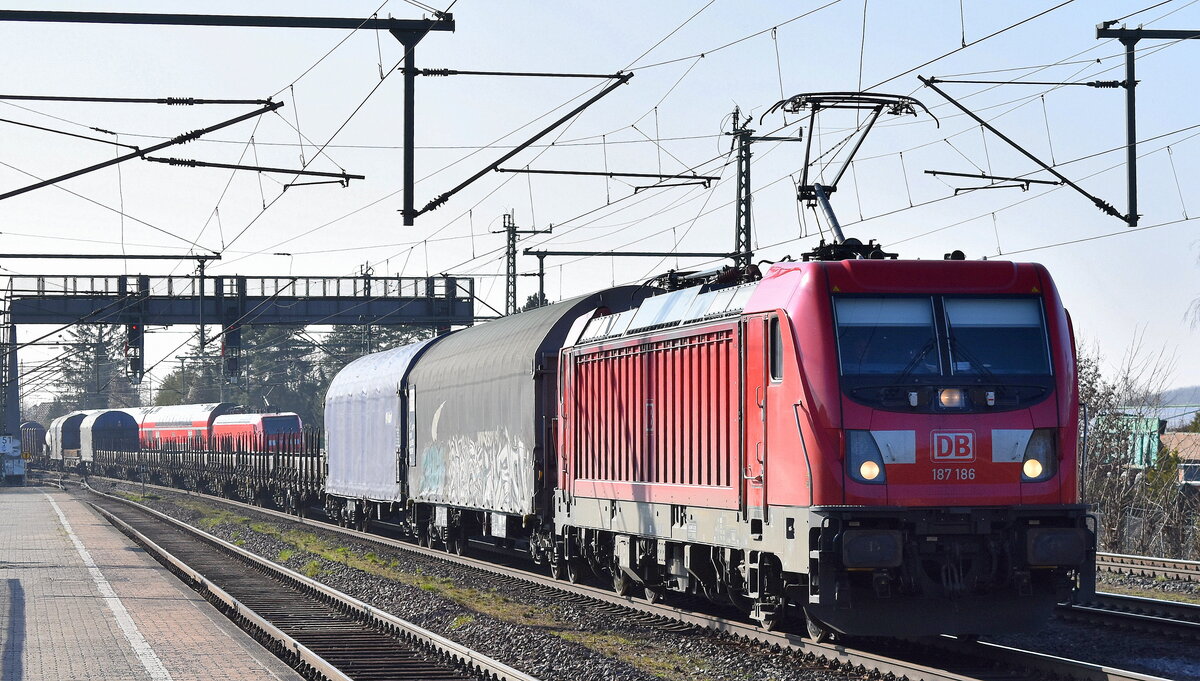 DB Cargo AG, Mainz [D]  187 186  [NVR-Nummer: 91 80 6187 186-2 D-DB] und einem gemischten Güterzug am 27.03.25 Höhe Bahnhof Niederndodeleben.